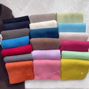 Flat lay of 100% wool scarves in 18 colors featuring a textured ribbed knit design