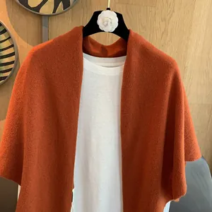 Detailed texture of dark red wool knitted shawl showing soft plush material and French style