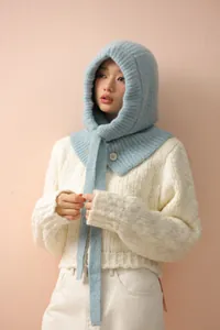 Détail d'une cagoule bleue tricotée avec boutons et mélange de laine pour l'hiver