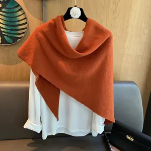 Macro detail of high-quality red wool triangle scarf showing soft knit texture and drape