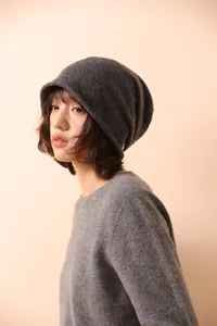 Dettaglio di un berretto in maglia grigio scuro con trama in cashmere e bordo arrotolato