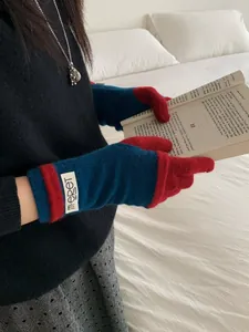 Detail of red and blue color-block knit arm warmers with a minimalist brand label