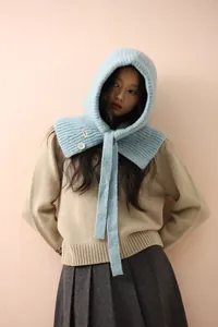Détail de la cagoule en tricot bleu clair avec boutons décoratifs et étiquette choice
