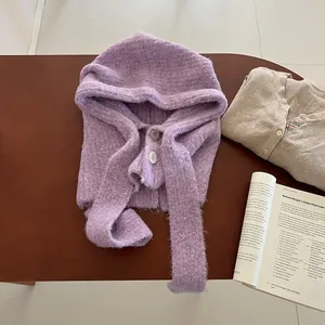 Detail of light purple knitted balaclava hood with white buttons on wooden background