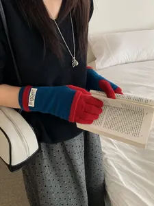 Close-up of color block knitted gloves in red and blue with touch screen fingertips