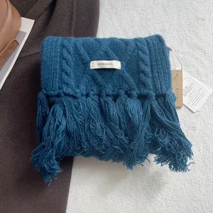 Detailed macro view of navy blue 100% wool scarf with cable knit texture and tassel edges