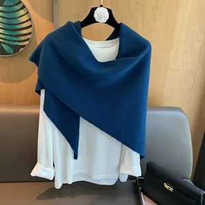 Close-up of dark blue 100% wool knitted scarf with soft texture draped on a hanger