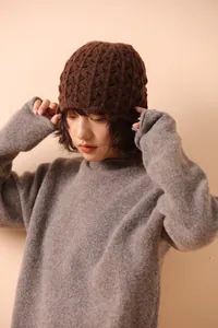 Detail of dark brown knit bucket hat featuring intricate hollow floral crochet pattern