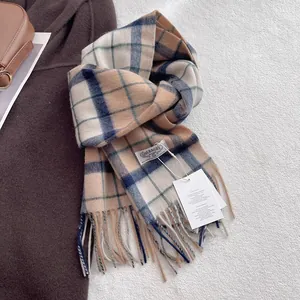 Close-up of wool plaid scarf with tassel fringe, brand label and stylish paper hangtag