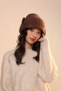 Dettaglio della trama a maglia a coste spesse e del design copriorecchie su un cappello marrone