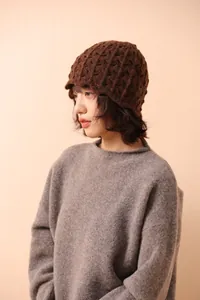 Close-up of dark brown knit bucket hat with textured crochet pattern for women