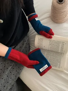 Detail of warm knit gloves with red and blue contrast design and tactile texture