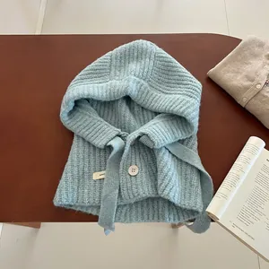 Cagoule écharpe en laine tricotée pour l'hiver avec boutons bleu clair sur décor cosy
