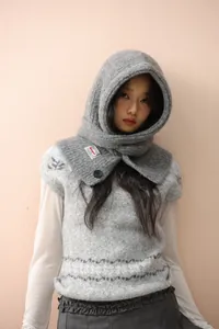 Close-up of grey knit Balaclava hood featuring black buttons and brand woven label