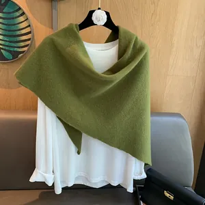 Macro detail of high-quality green wool knit texture on a triangle scarf shawl layer