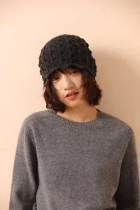 Close-up of grey wool knit bucket hat showing intricate crochet diamond mesh pattern