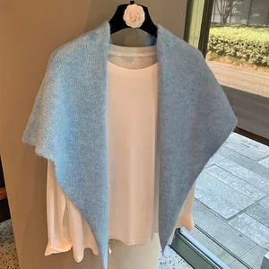 Close-up of light blue mohair texture knit shawl over a white long sleeve shirt