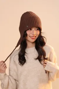Dettaglio del cappello in maglia marrone scuro con paraorecchie e trama a coste