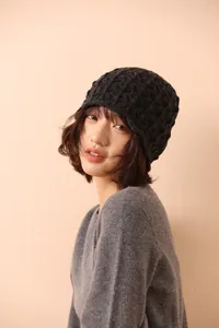 Detailed view of dark grey wool knit hat with intricate honeycomb crochet and lace patterns