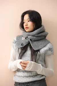 Detail of grey knitted balaclava hood with large black button and warm knit texture