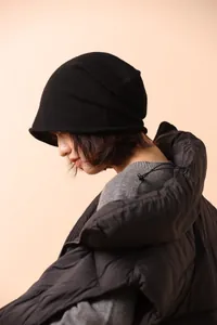 Dettaglio del cappello di lana nera lavorato a maglia con bordo arrotolato stile moderno