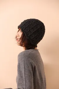 Close-up of deep gray wool knit hat with colorful flecks and cable stitch detail