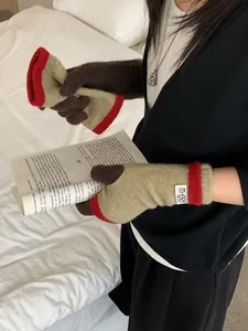 Detail of warm knit gloves with color-block design and brand woven label on wrist