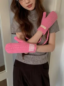 Detail of pink cable knit mittens with neck string and branded woven label feature