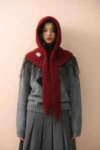 Close-up of deep red knitted balaclava hood with button detail and wool texture