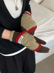 Detailed knit texture of color-block winter gloves with orange and beige accents