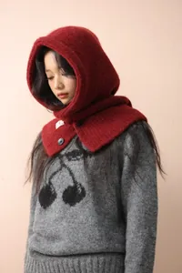 Close-up of soft dark red knit balaclava with warm texture and black button detail
