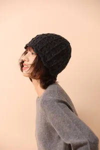 Detail of dark grey wool knit hat featuring thick crochet hollow lace and rhombus patterns