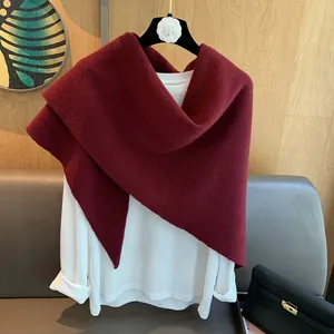 Close-up of a deep red 100% wool knitted shawl with soft texture on a white top