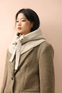 Détail d'une cagoule en maille beige avec nœud papillon pour la chaleur d'hiver