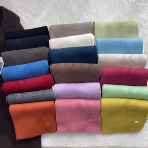 Bunte Auswahl an Wollschals mit Rippenstrickmuster auf einem weißen strukturierten Hintergrund