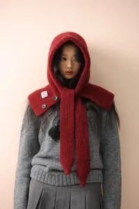 Detail of red knit balaclava hat with fluffy mohair texture and button closure