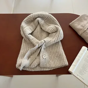 Vue détaillée du bonnet balaclava en tricot beige avec boutons et cordon de serrage