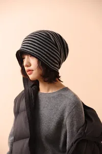 Dettaglio della trama a maglia a righe nere e grigie del berretto alla moda
