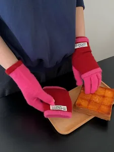 Detail of pink and dark red knitted touch screen gloves with wrist warmers for winter warmth