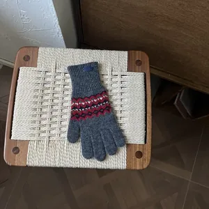 Detail der Strickhandschuhe mit Fair-Isle-Muster, grauem Jacquard und Rippbündchen
