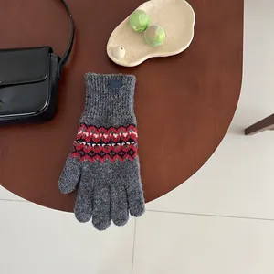 Detail der Fair-Isle-Musterung an grauen Strickhandschuhen mit Touchscreen-Funktion