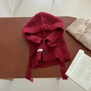Détail de cagoule écharpe bordeaux en laine avec boutons et texture en maille côtelée