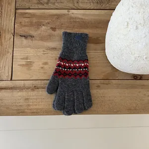 Detail von dunkelgrauem Fair-Isle-Strickhandschuh mit dickem Rippbündchen auf Holztisch