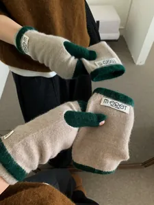 Detail of knitted oatmeal fingerless gloves with contrast dark green ribbed cuffs