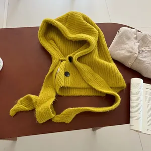 Detail of ginger knit balaclava showing ribbed texture and black button closure
