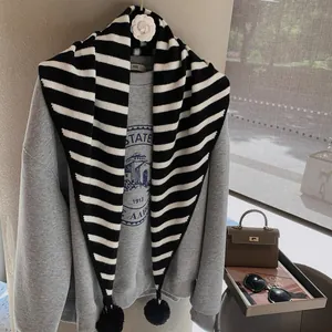 Black and white striped knitted triangle scarf with cute pom-poms and camellia decor