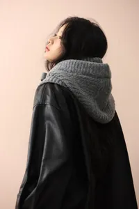 Détail de la cagoule écharpe à capuche en grosse maille de laine grise pour l'hiver