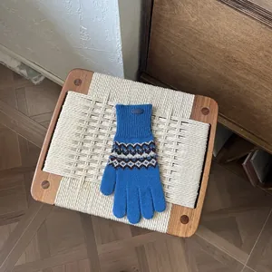Detail von blauem Fair-Isle-Strickhandschuh mit Geometriemuster und Rippbündchen