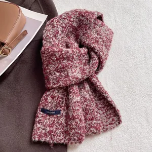 Dettaglio della sciarpa invernale spessa in misto lana con maglia bordeaux e beige