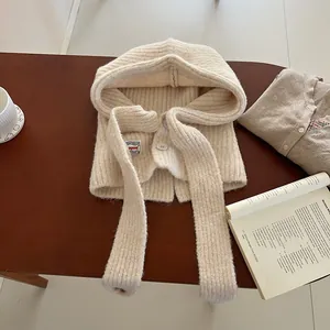 Detailed close-up of cream knit balaclava hood featuring ribbed texture and button closure